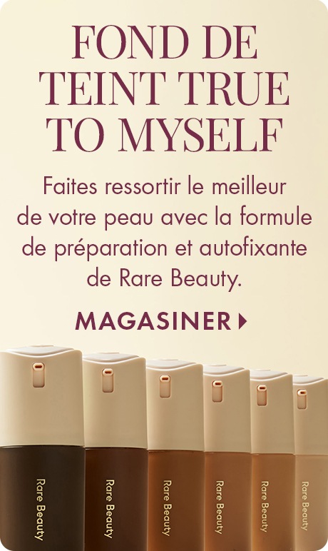 Fond de teint crème avec texte « Fond de teint True to Me ». Ci-dessous : « Faites ressortir le meilleur de votre peau avec la formule autoapprêtée, autofixante de Rare Beauty » et « Magasiner ». Une rangée de bouteilles de fond de teint Rare Beauty dans p