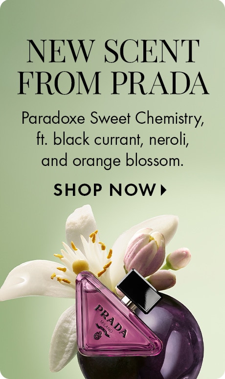 « NOUVEAU PARFUM DE PRADA » « Voici Paradoxe Sweet Chemistry, avec cassis, néroli et fleur d’oranger ». « MAGASINER » Publicité avec un fond vert pâle, des pétales floraux et des fleurs, et une bouteille de parfum triangulaire rose Prada contre un fruit vi
