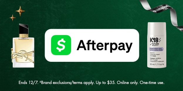 This image features a YSL fragrance bottle and a K18 haircare product on a festive green background with ribbon and stars. The Afterpay logo is centered, promoting online shopping and holiday gifting.