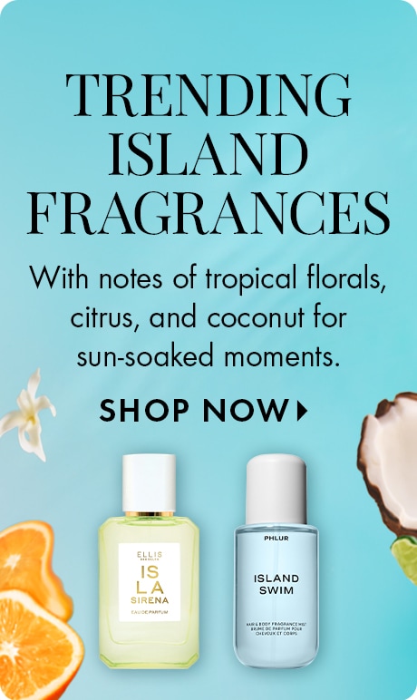 Blue background with text: “TRENDING ISLAND FRAGRANCES. With notes of tropical florals, citrus, and coconut for sun-soaked moments. SHOP NOW > .” Two bottles: Ellis Brooklyn “ISLA” and Phlur “ISLAND SWIM,” with orange slices, flower, and coconut.