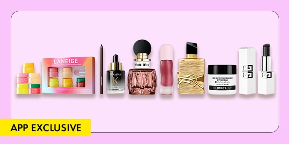 "APP EXCLUSIVE" Assorted beauty products including a Laneige skincare set, hair serum, fragrance, lip product, YSL lipstick, moisturizer, and two travel-size bottles on a lavender background. Provide your feedback on BizChat