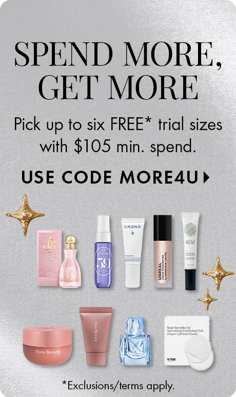 "SPEND MORE, GET MORE" with text: "Pick up to six FREE* trial sizes with $105 min. spend." and "USE CODE MORE4U. * Exclusions/terms apply." Silver textured background with gold star accents and beauty products arranged in rows at the bottom.