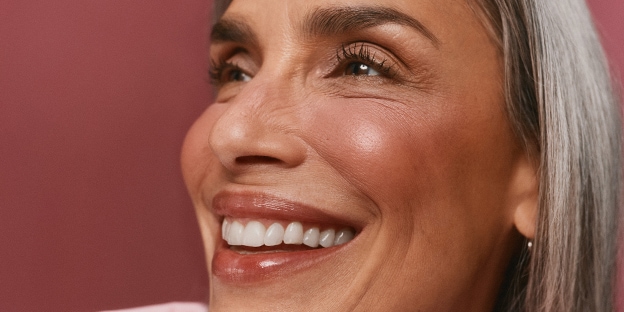 A smiling woman next to the text "Makeup Math: When 1 + 1 = need them both" on a mauve background.