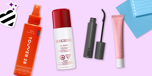 Four beauty products on a lavender background: an orange Tower 28 spray bottle, a red-and-white ONE/SIZE bottle, a gray REFY mascara with wand, and a pink Summer Fridays tube. Decorative heart sticker and blue paper accents appear in the corners.