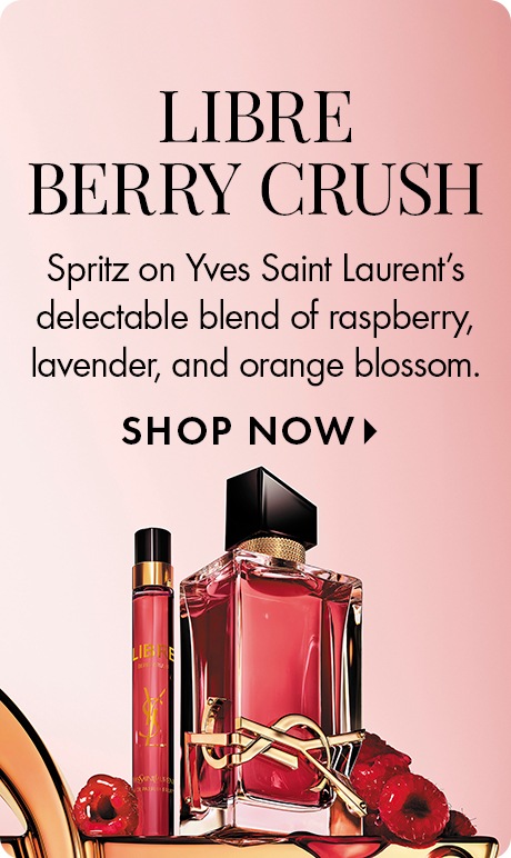 Pink background with text reading “Libre Berry Crush” and “Spritz on Yves Saint Laurent’s blend of raspberry, lavender, and orange blossom.” Below are two perfume bottles, one tall and slim, one square, surrounded by raspberries, with a “Shop Now” prompt.