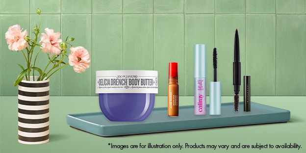  A striped vase with pink flowers sits on the left beside a tray displaying various beauty products, including a purple body butter jar and several makeup items, against a green tiled background.