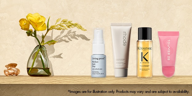 Living Proof Perfect Hair Day Dry Shampoo, rhode Peptide Glazing Fluid, Kérastase Elixir Ultime Hair Oil, and Tower 28 ShineOn Lip Jelly displayed on a shelf beside a small vase with yellow flowers.