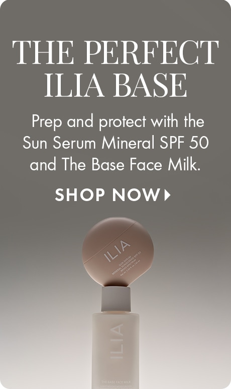 Neutral gray background with text reading “The Perfect Ilia Base.” Below: “Prep and protect with the Sun Serum Mineral SPF 50 and The Base Face Milk,” followed by “Shop Now.” An Ilia bottle stands with a round compact balanced on top.