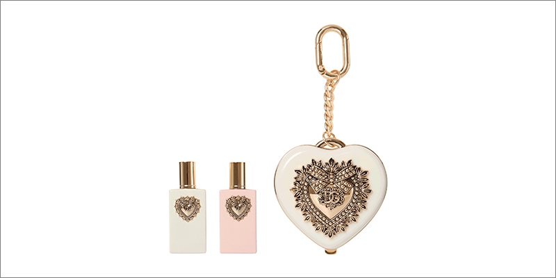 Dolce & Gabbana beauty products including two fragrance bottles and a heart-shaped compact mirror with gold detailing
