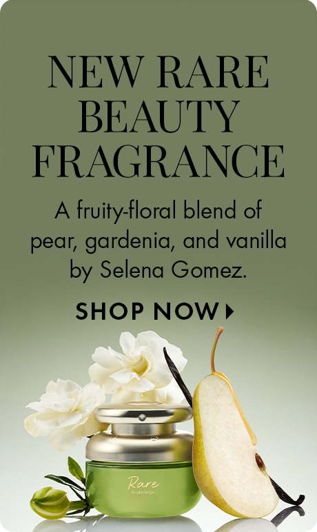 "NEW RARE BEAUTY FRAGRANCE" "A fruity-floral blend of pear, gardenia, and vanilla by Selena Gomez." "SHOP NOW" Green-toned promotional banner featuring a Rare Beauty perfume jar surrounded by white flowers, a sliced pear, vanilla beans, and leaves.