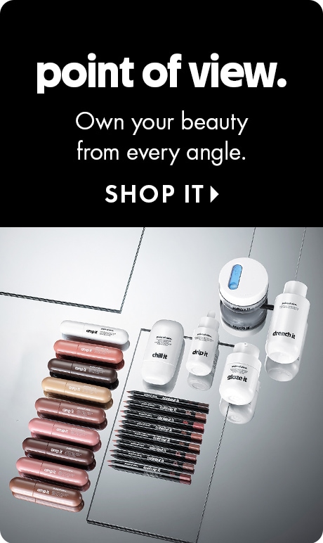 "point of view." "Own your beauty from every angle." "SHOP IT" Beauty ad with a black header and an assortment of cosmetic products displayed on mirrored surfaces below, including lip products, pencils, jars, and bottles.