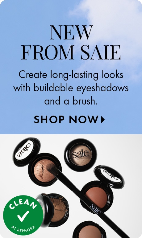 "NEW FROM SAIE." Text: "Create long-lasting looks with buildable eyeshadows and a brush." "SHOP NOW." Blue sky background above open Saie eyeshadow pots, a makeup brush, and a green "CLEAN AT SEPHORA" checkmark badge.