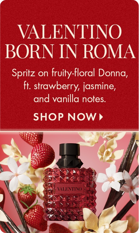 "VALENTINO BORN IN ROMA." Text: "Spritz on fruity-floral Donna, ft. strawberry, jasmine, and vanilla notes." "SHOP NOW." Red background above a Valentino perfume bottle surrounded by strawberries, flowers, and vanilla pods.