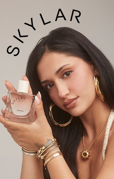 Skylar. Image of model with fragrance bottle.